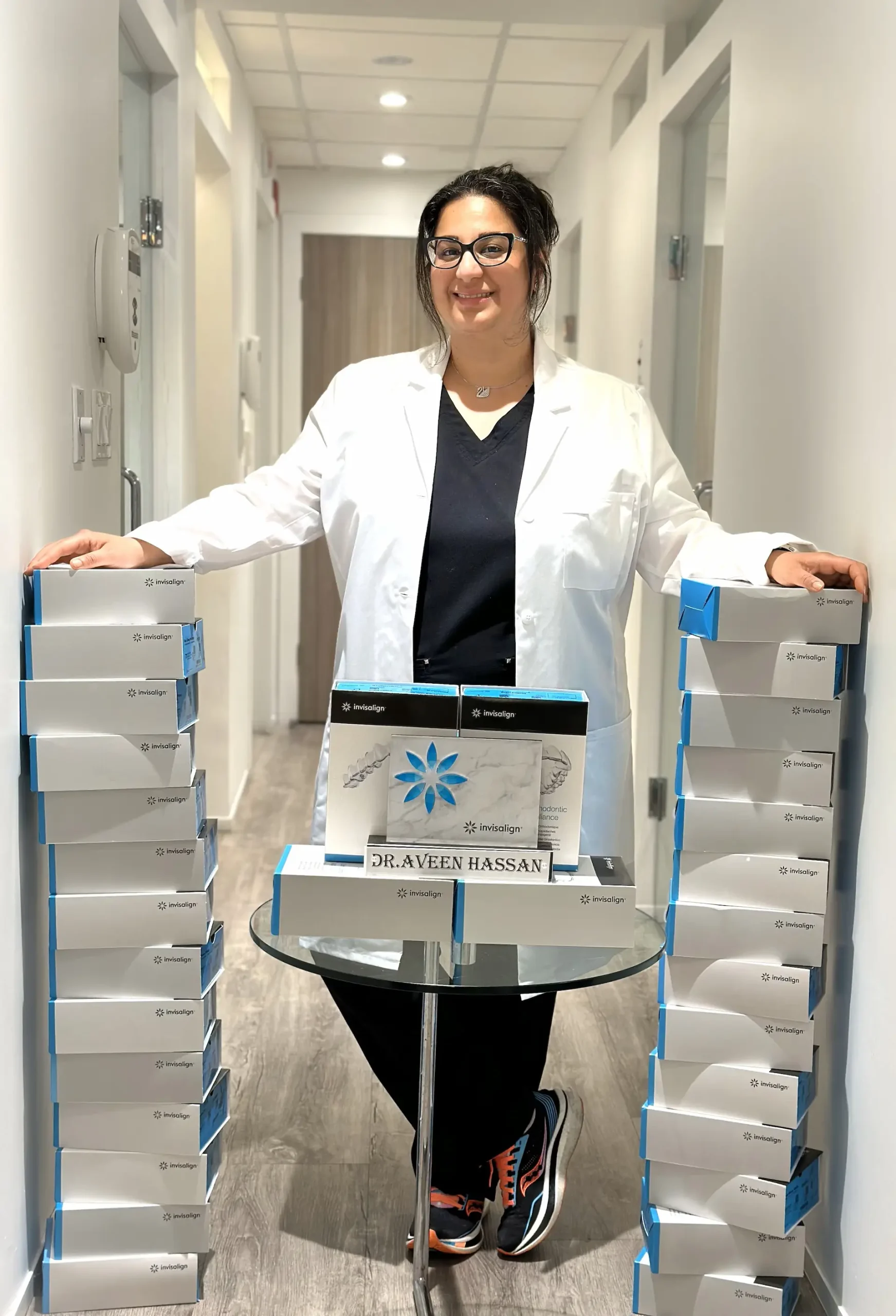Dr. Aveen Hassan with Invisalign aligner cases at the Midtown Toronto clinic